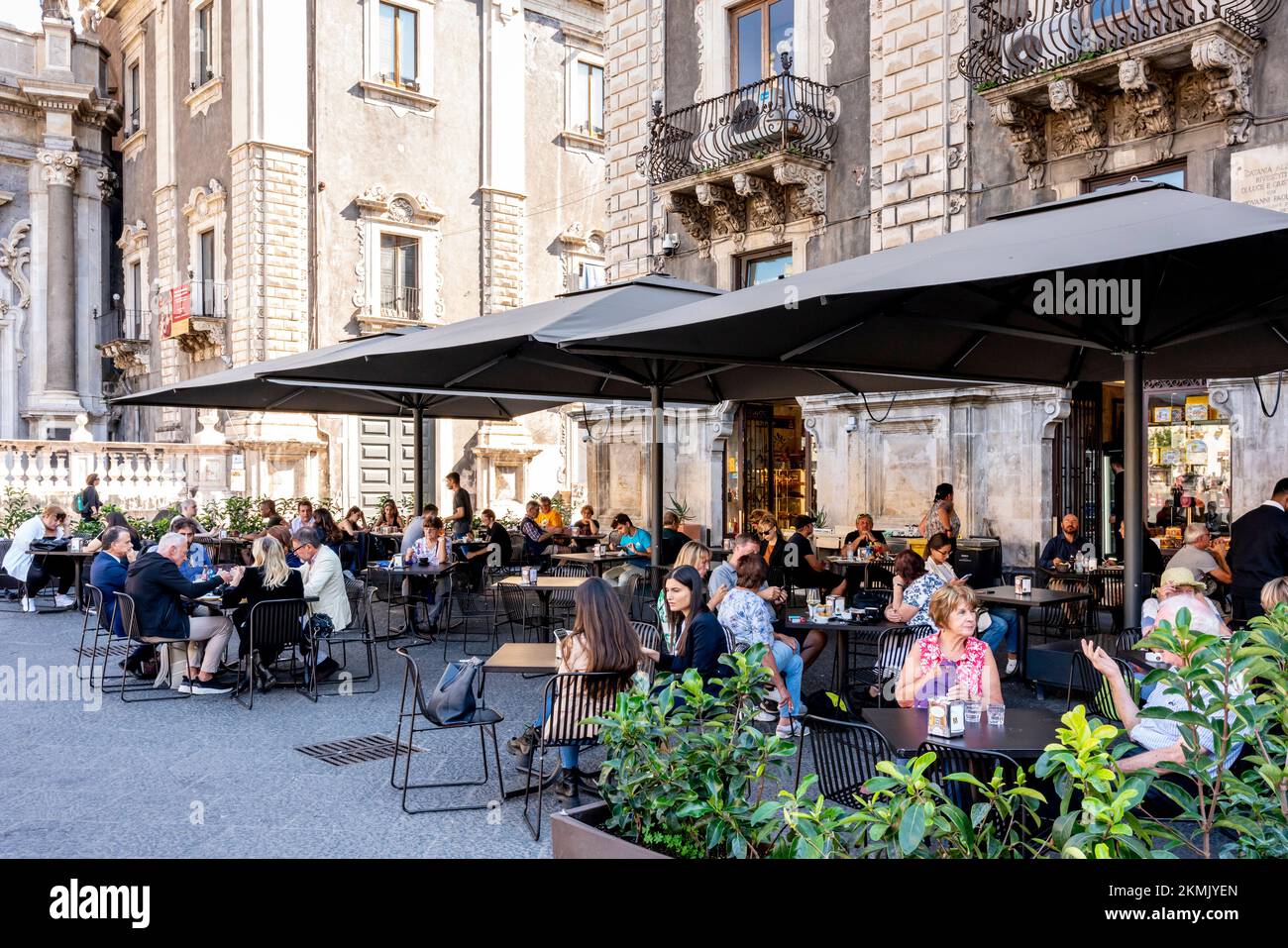 Persone sedute presso un caffè/ristorante all'aperto in Piazza del Duomo, Catania, Sicilia, Italia. Foto Stock