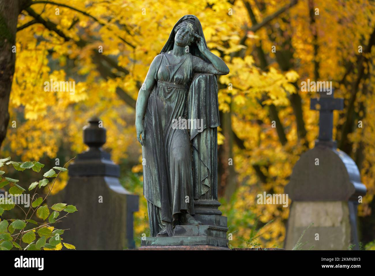 triste statua donna in piedi su una tomba nel cimitero d'autunno Foto Stock