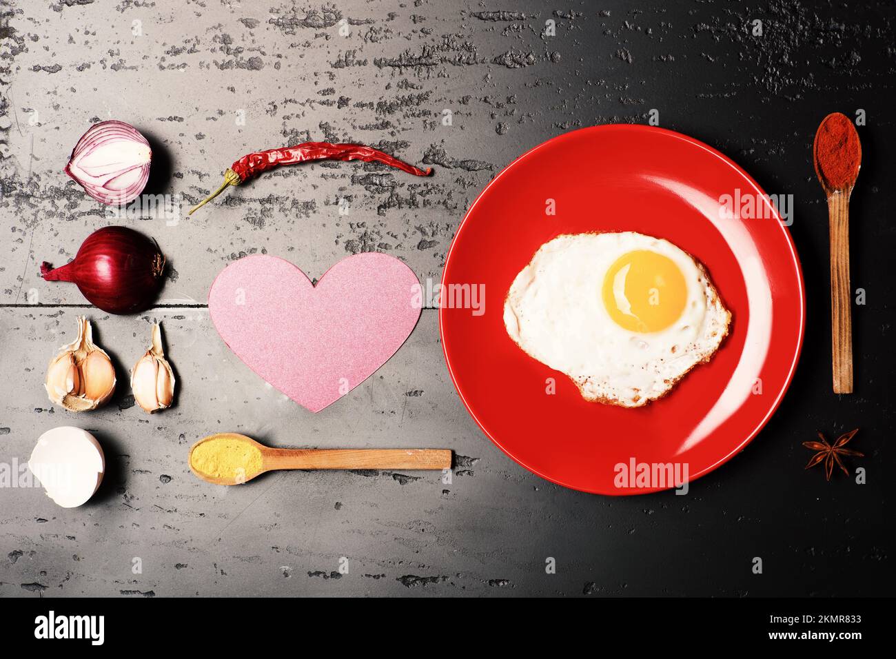 Cibo messo su piatto rosso su sfondo scuro. Foto Stock