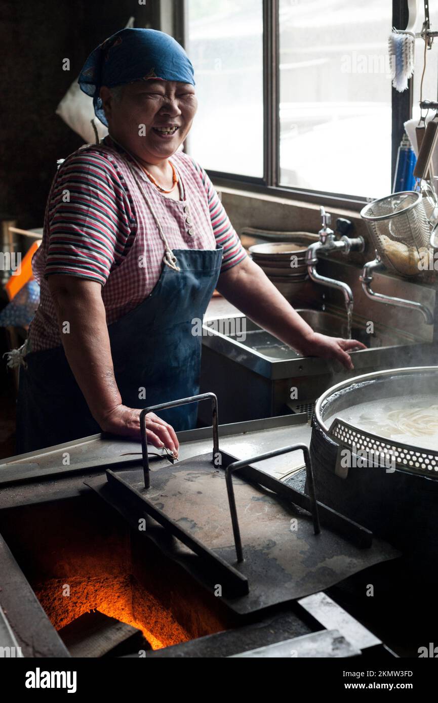 Gli spaghetti vengono cucinati in bollitori a fuoco lento su un fuoco di legno nel modo tradizionale a Yamauchi Udon, Shikoku. Foto Stock