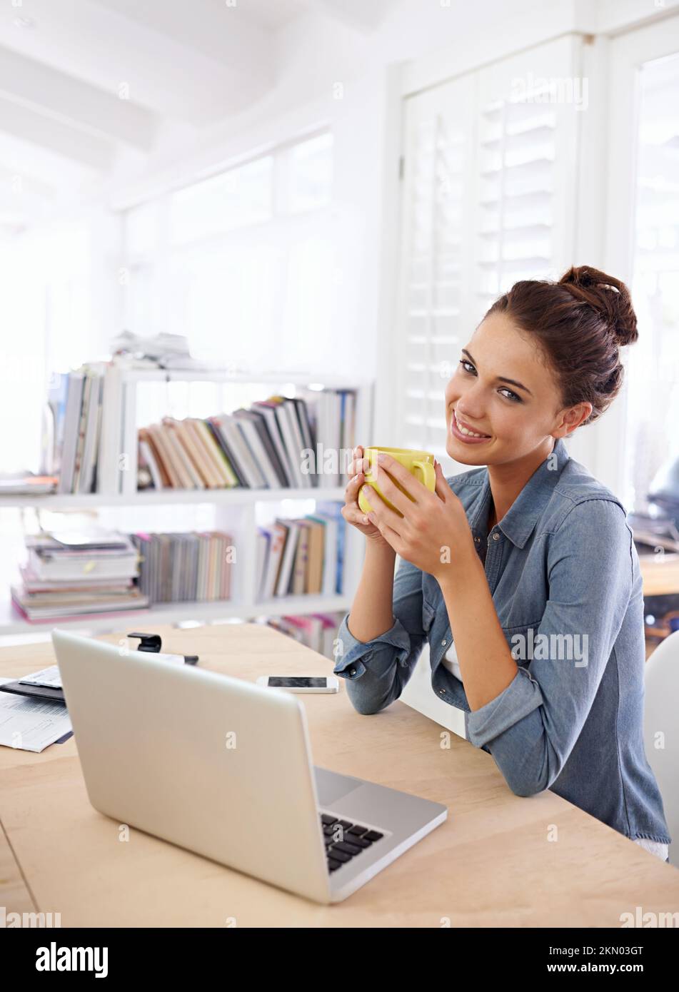 Mi piace lavorare da casa. una donna attraente che usa il suo notebook a casa. Foto Stock