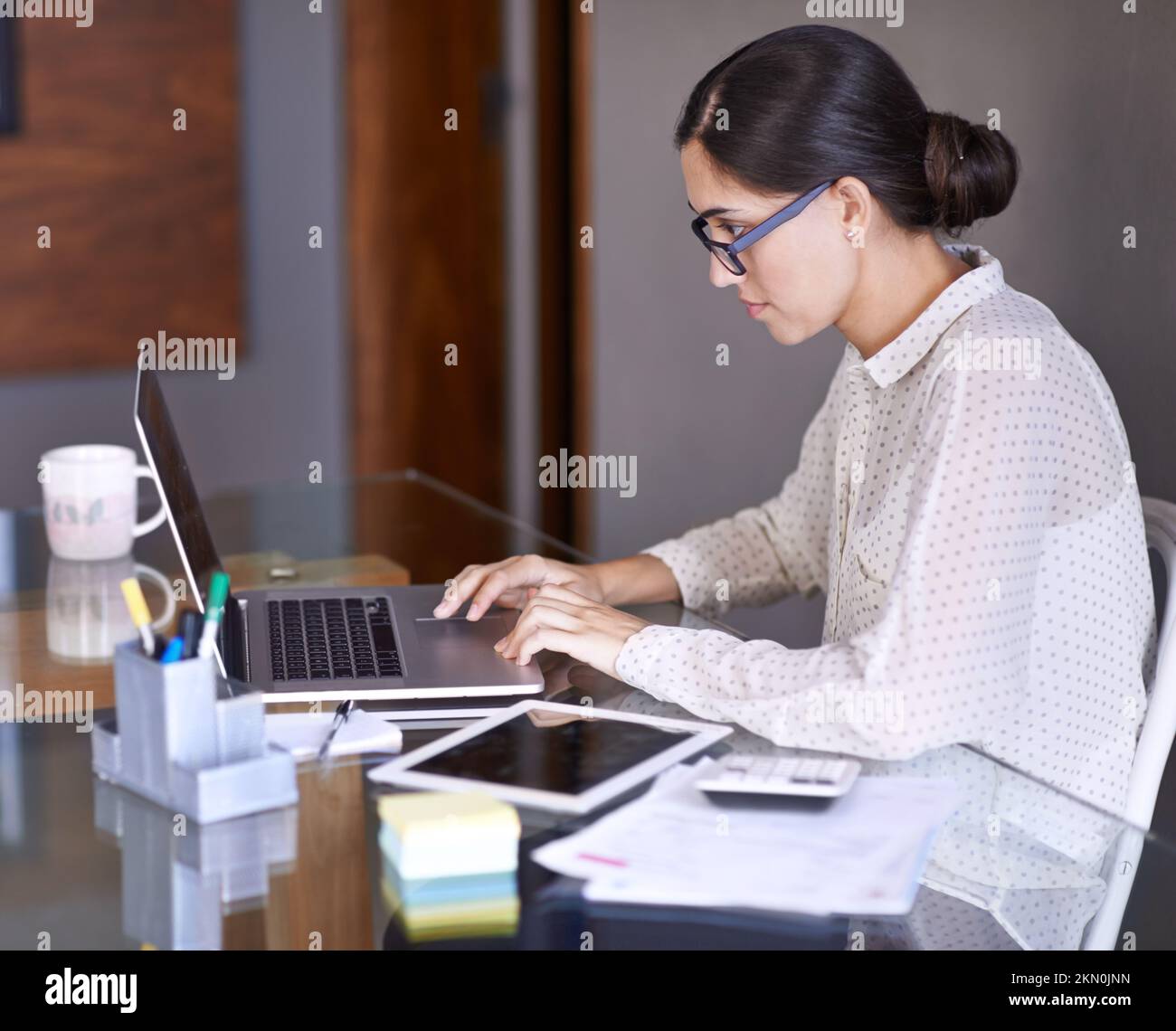 Lavorare sodo da casa. una bella giovane donna che lavora sul suo notebook. Foto Stock
