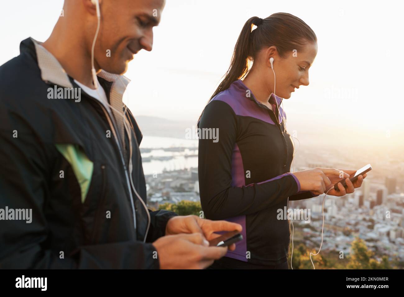 Pronti a partire con alcuni brani fantastici. Una coppia che sceglie la musica sui loro telefoni cellulari prima del loro workout di corsa. Foto Stock