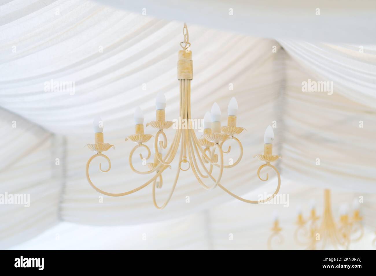Delicato lampadario negli interni cerimoniali di casa. Design interno pastello e tenui. Foto Stock