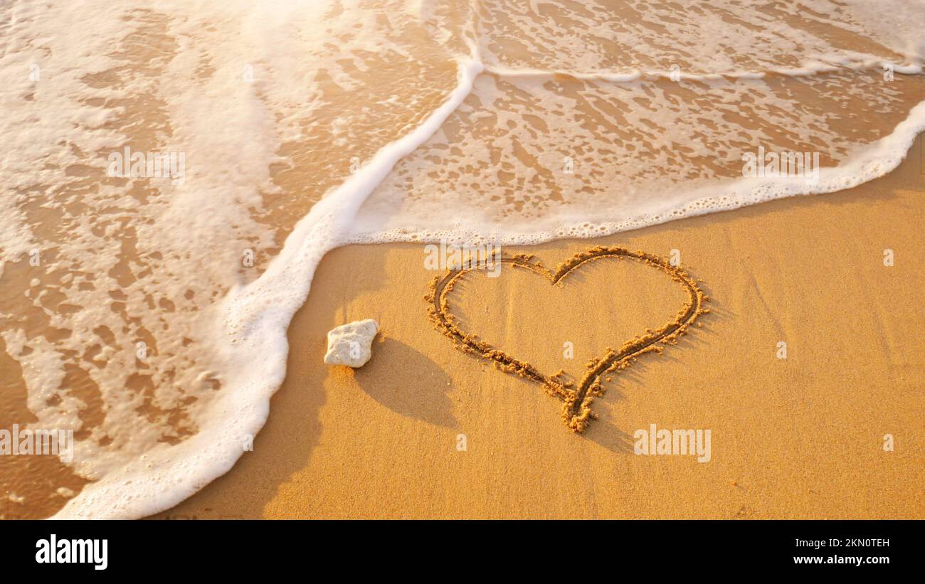 Simbolo del cuore sulla spiaggia di mare. Composizione romantica. Foto Stock