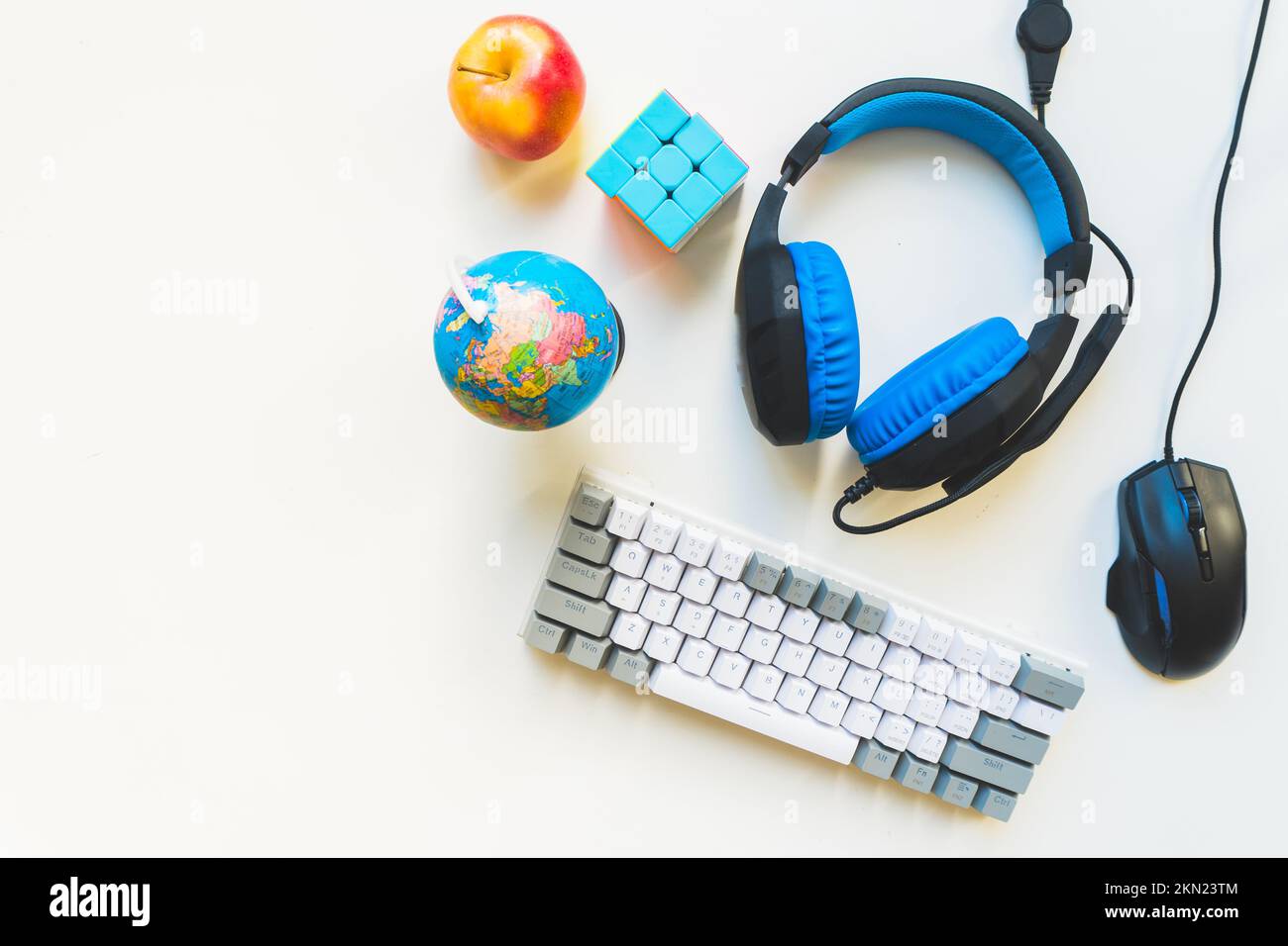 Vista dall'alto concetto di spazio di lavoro per studenti, mouse, tastiera, cuffia su sfondo bianco con spazio per le copie e sviluppo per bambini. Studi remoti elementari Foto Stock