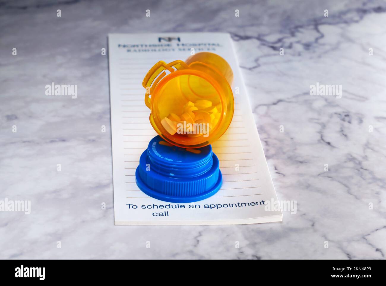 Aprire il flacone del medicinale con le pillole per qualcuno. sulla parte superiore di un pad di prescrizione Foto Stock