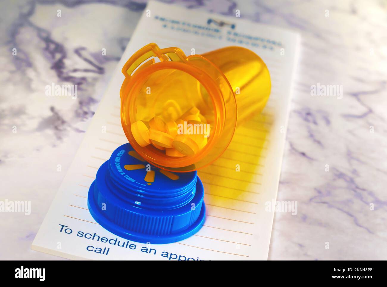 Aprire il flacone del medicinale con le pillole per qualcuno. sulla parte superiore di un pad di prescrizione Foto Stock