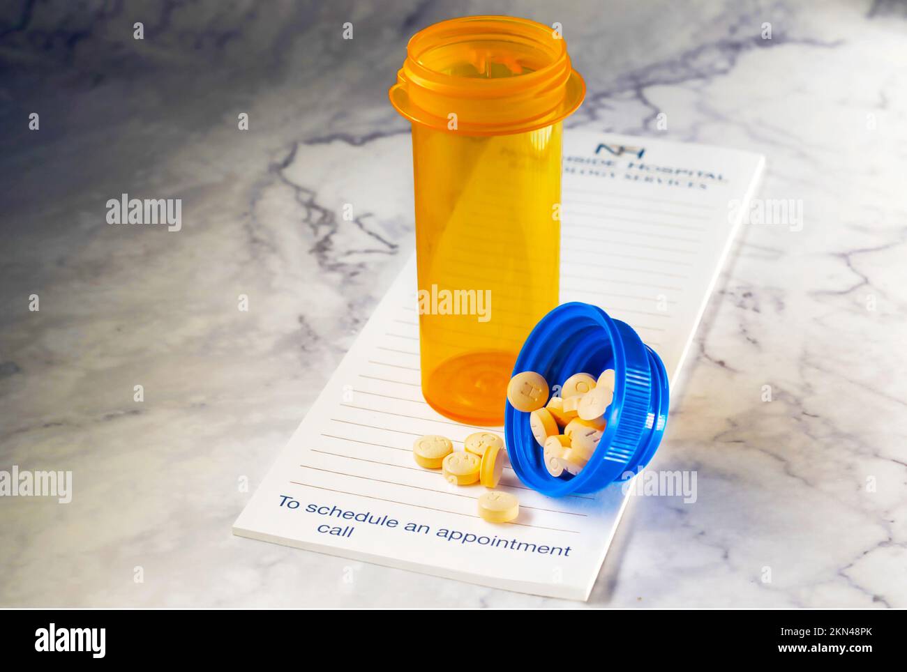 Aprire il flacone del medicinale con le pillole per qualcuno. sulla parte superiore di un pad di prescrizione Foto Stock