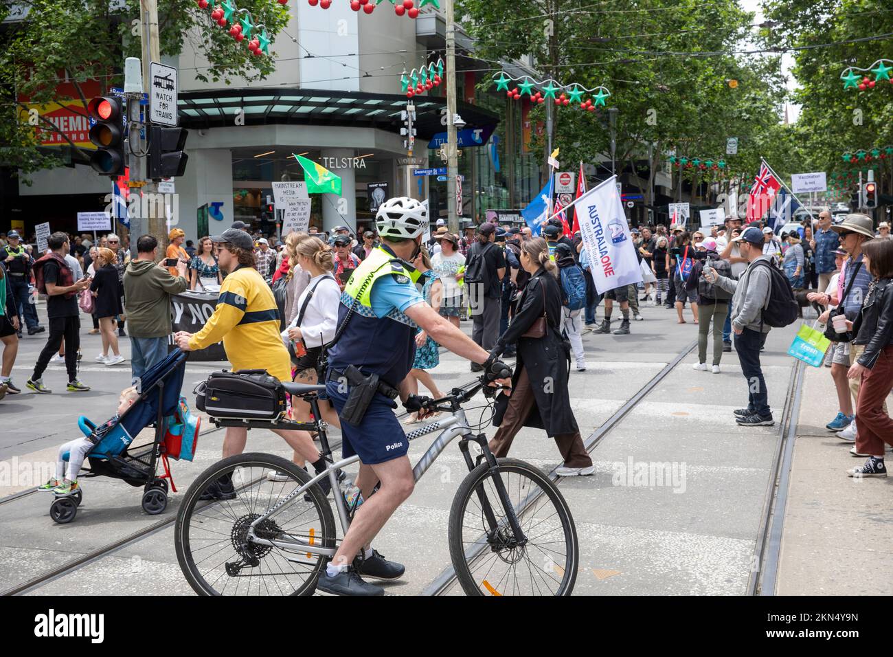 Il poliziotto di Melbourne controlla i manifestanti di strada contro le misure del covid 19 che guidano una bicicletta della polizia e che indossano gli shorts,Melbourne,Vic,Australia Foto Stock