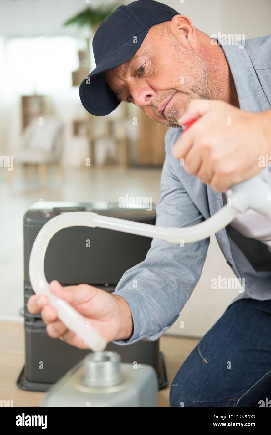 uomo che riempie l'umidificatore con acqua Foto Stock