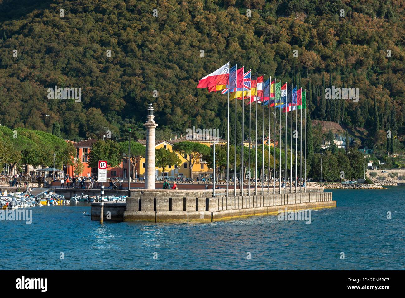 Porto di Garda Lago di Garda, vista in estate dell'ampio frangiflutti / molo in pietra che racchiude il porticciolo sul lago nel centro storico di Garda, Veneto, Italia Foto Stock