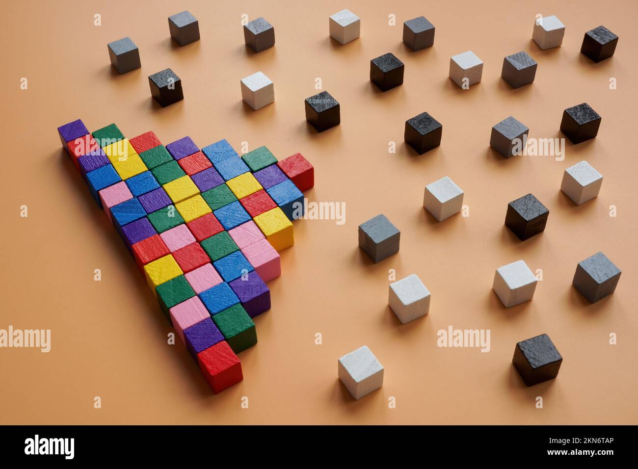 Piramide dai cubi colorati e quelli grigi e neri intorno. Diversità e inclusione nella società. Foto Stock