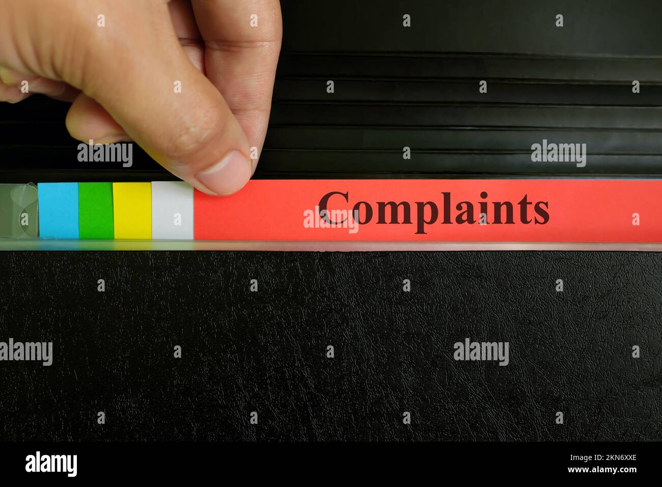 Record del file reclami prelievo a mano nella cartella raccoglitore nero. Concetto di business e criminalità dei reclami dei clienti. Foto Stock