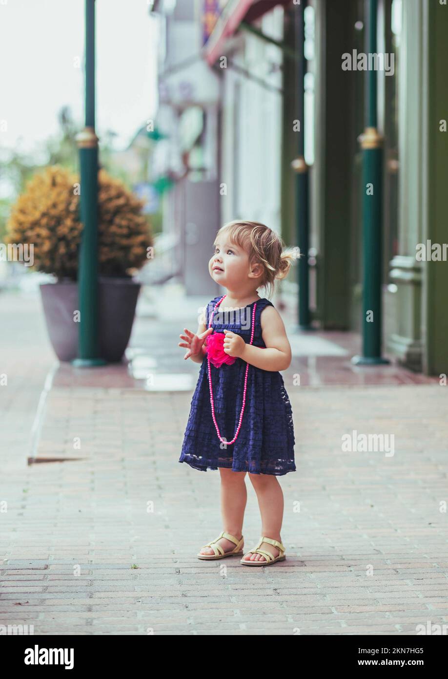 bella bambina in vestito per strada Foto Stock