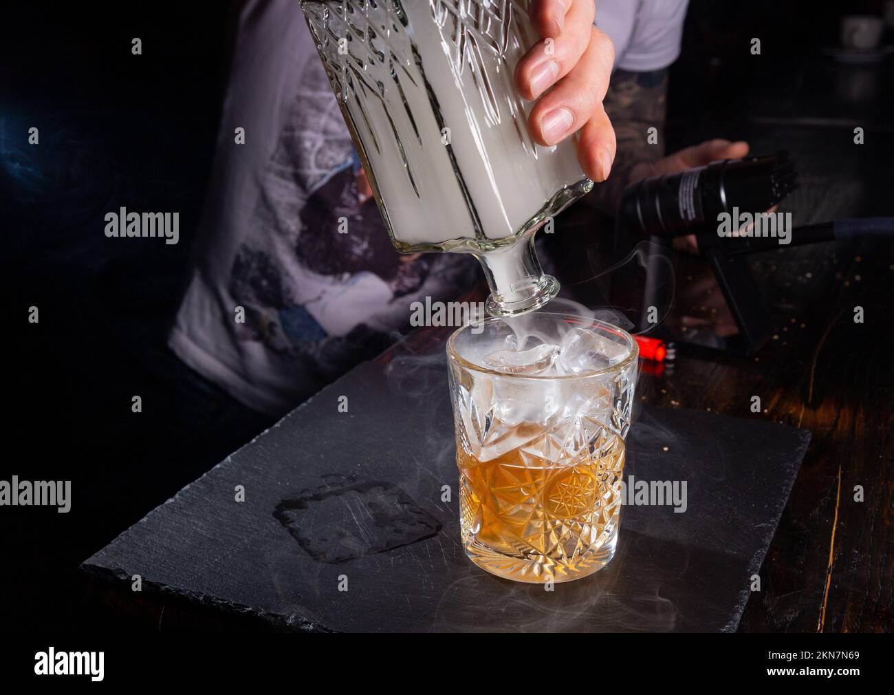 Il barman mescola il whiskey con il fumo per dare un sapore speciale alla bevanda. Il fumo migliore per questo scopo è ottenuto bruciando segatura di ontano. A s Foto Stock