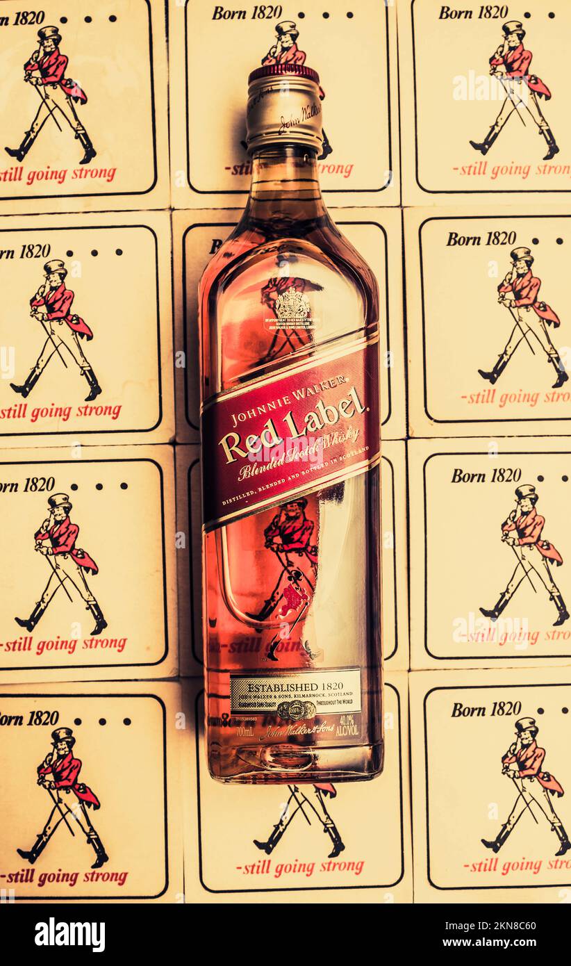 Pubblicità di alcool d'epoca su una bottiglia di whisky della Johnnie Walker Red Label posta su un'antica costa da collezione. Arte della parete del bar Foto Stock
