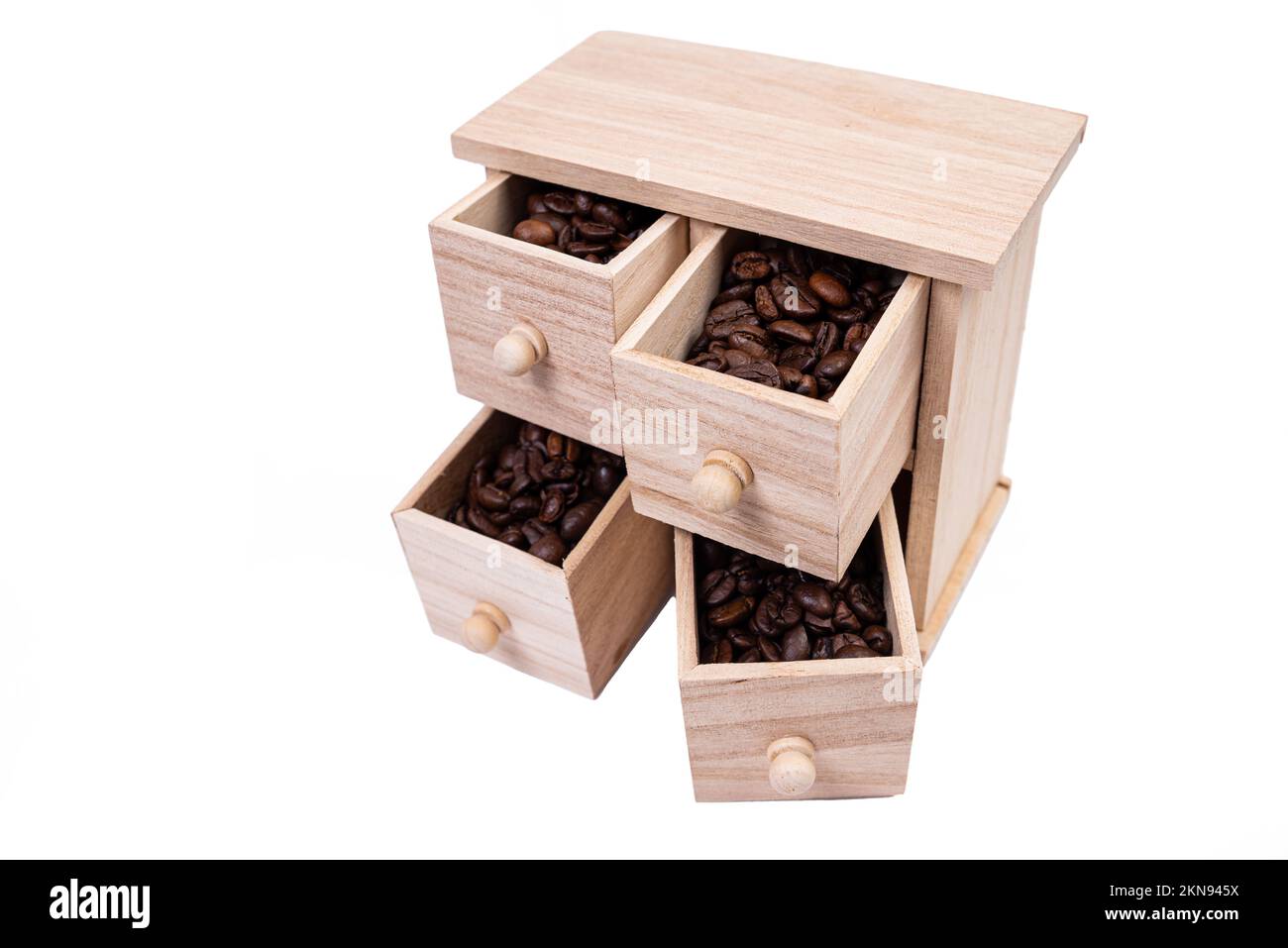Scatola di legno con celle riempite di chicchi di caffè. Chicchi di caffè sparsi fianco a fianco isolati su sfondo bianco Vista dall'alto Foto Stock