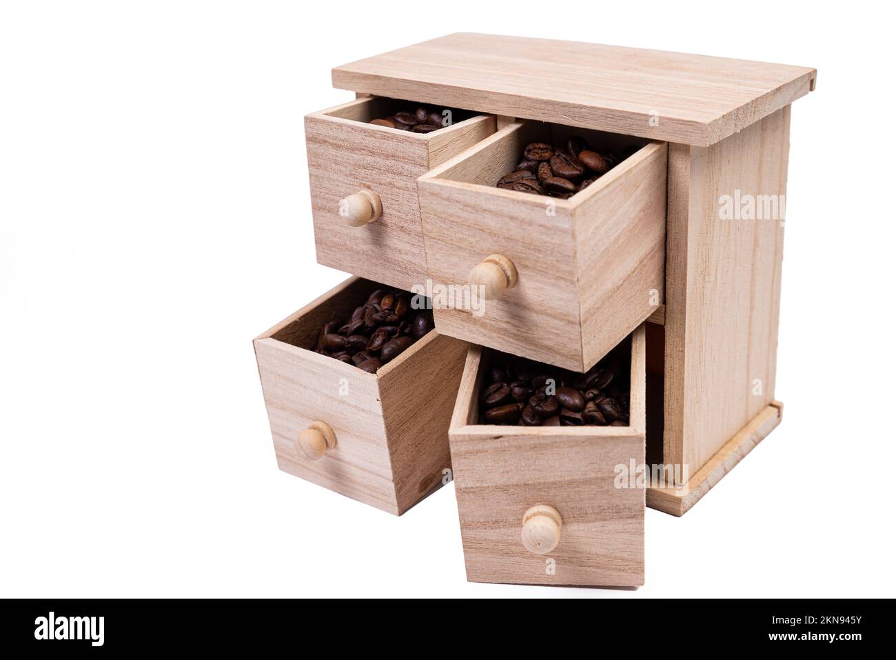 Scatola di legno con celle riempite di chicchi di caffè. Chicchi di caffè sparsi fianco a fianco isolati su sfondo bianco Vista dall'alto Foto Stock