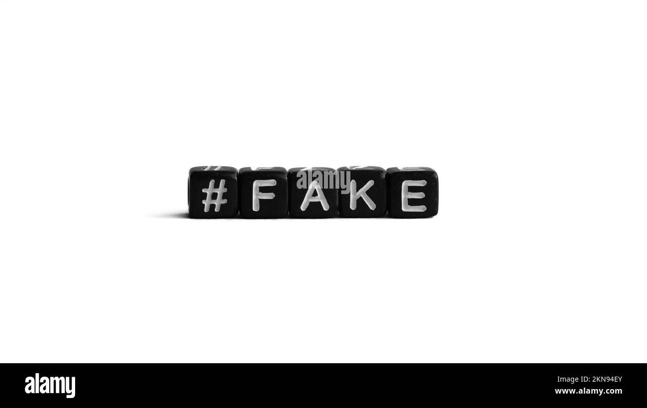 Perline di lettere nere con hashtag e parola falsa su sfondo bianco. Notizie false e concetto di propaganda Foto Stock