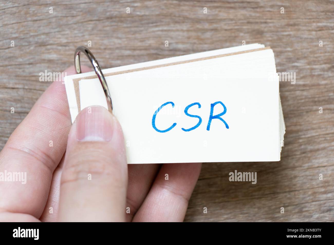 Scheda flash con impugnatura in parola CSR (abbreviazione di responsabilità sociale d'impresa) su sfondo legno Foto Stock