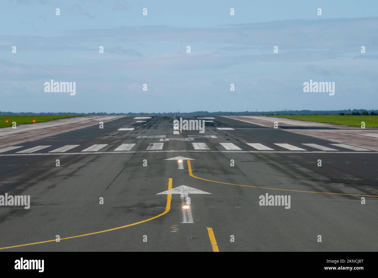 soglia della pista aeroportuale con illuminazione e segnaletica Foto Stock