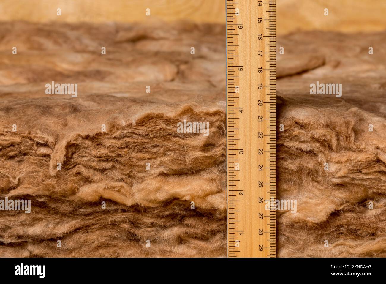 Misurazione isolamento in fibra di vetro in soffitta di casa con righello. Risparmio energetico domestico, costi di riscaldamento e raffreddamento e concetto di costruzione. Foto Stock