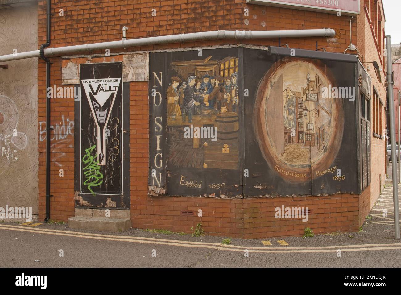 Swansea, Galles, nome di pub insolito nel Regno Unito. Vista della strada dell'angolo di un edificio costruito in mattoni. Immagini murali che ritraggono i festeggiamenti e la strada dei giorni passati. Foto Stock