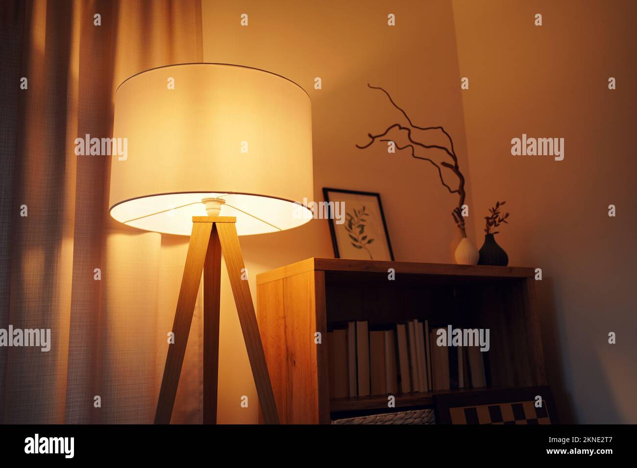 Paralume decorativo della lampada con luce calda accanto a uno scaffale Foto Stock