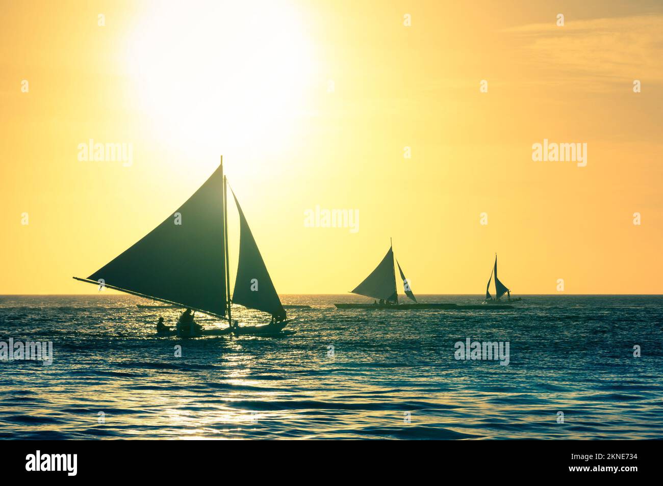 Silhouette di tipiche barche a vela al tramonto in Boracay Island - esclusiva destinazione di viaggio nelle Filippine - annata calda filtrata guardare Foto Stock