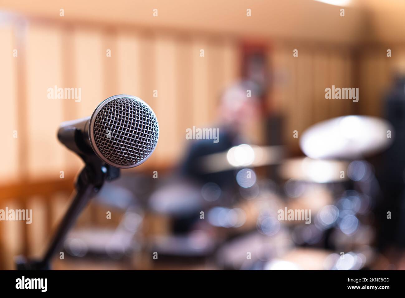 Dettaglio della griglia frontale metallica del microfono contro lo spazio di copia di sfondo sfocato sulla destra, palcoscenico di performance audio canto vocale Foto Stock