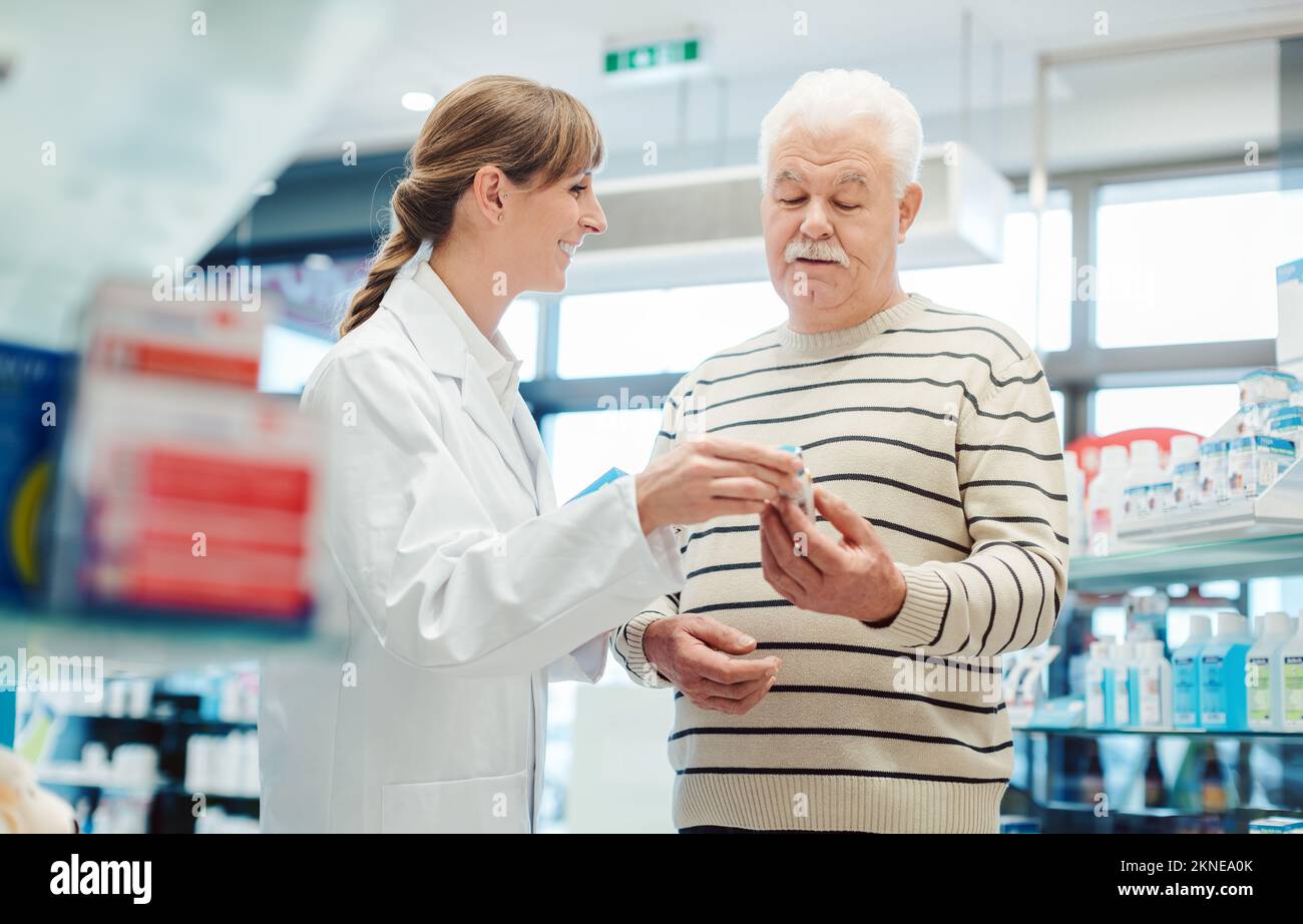 Uomo anziano con farmacista in farmacia Foto Stock