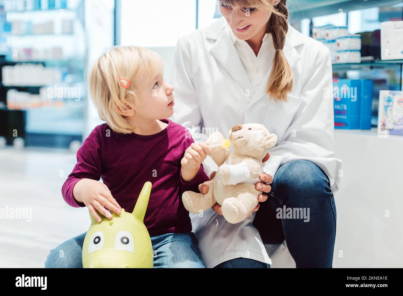 Bambina in farmacia che parla con la farmacia Foto Stock