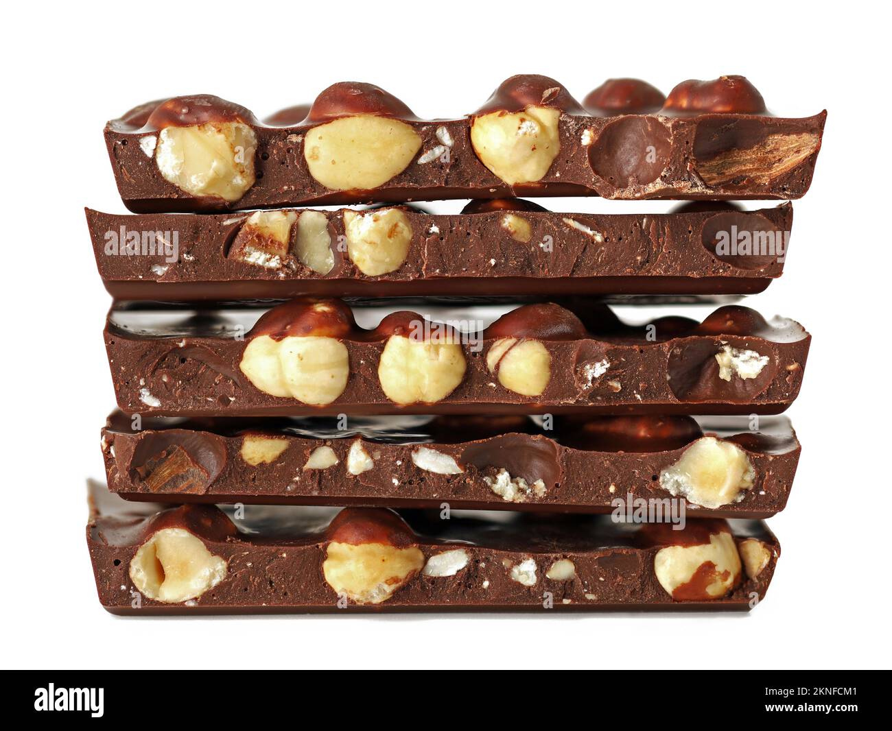 pila di tavolette di cioccolato rotte con nocciole isolate su sfondo bianco, vista laterale di cioccolato fondente con noci Foto Stock