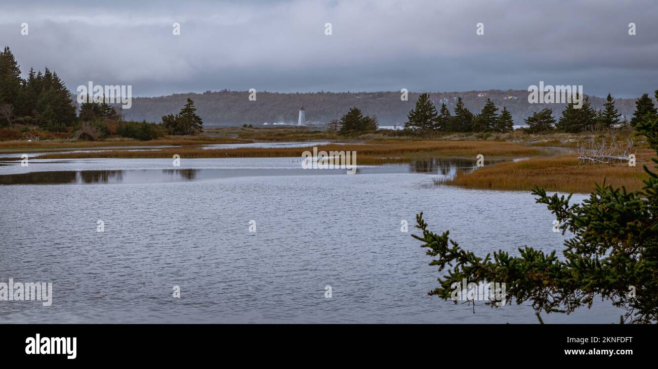 Guardando il faro sulla spiaggia di Maughers da McNabs Pond sull'isola di McNabs, Halifax, Nuova Scozia, Canada Foto Stock