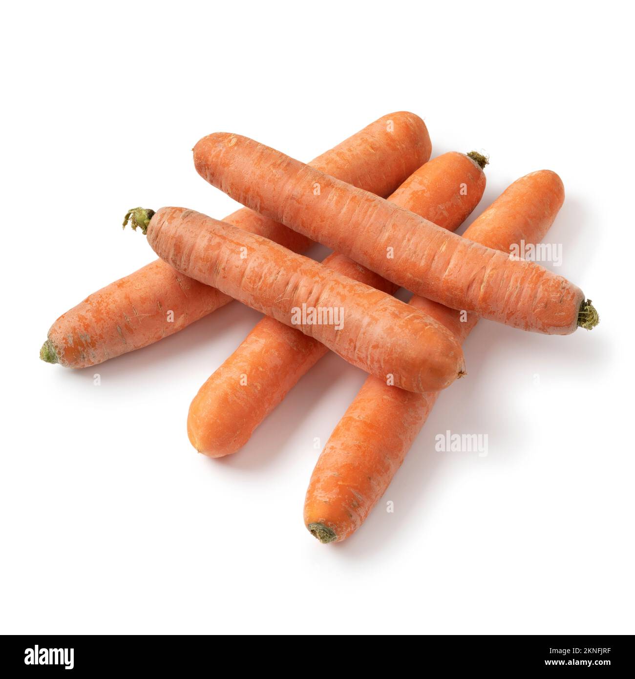 Mazzo di carote fresche crude e dolci invernali primo piano isolato su sfondo bianco Foto Stock
