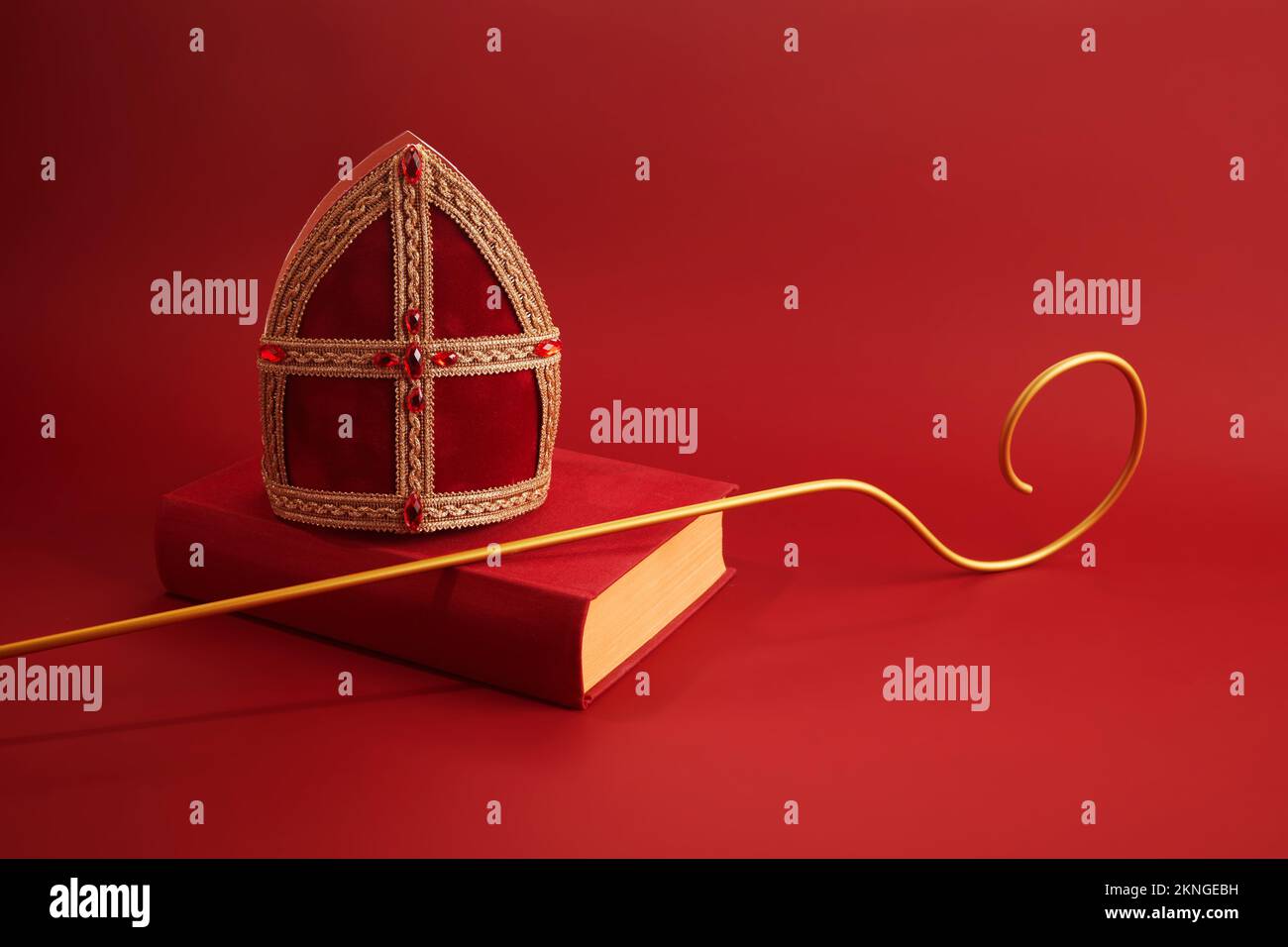 6th dicembre giorno di San Nicola - Sinterklaas. MITER di San Nicola e libro su tavolo rosso Foto Stock