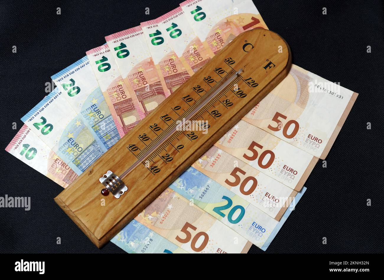 Simbolo immagine aumento dei costi di riscaldamento: Termometro con banconote in euro Foto Stock