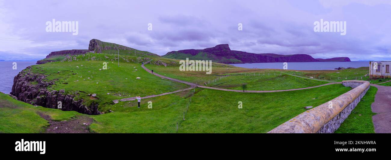 Glendale, Regno Unito - 29 settembre 2022: Vista panoramica al tramonto di scogliere e rocce costiere, con pecore e visitatori, a Neist Point, l'isola di Skye, interno Foto Stock