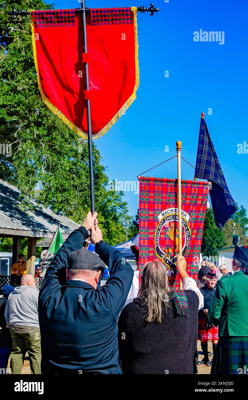 Durante la sfilata di tartan al Celtic Music Festival e ai Scottish Highland Games di Gulfport, Mississippi, le persone portano striscioni di tartan. Foto Stock