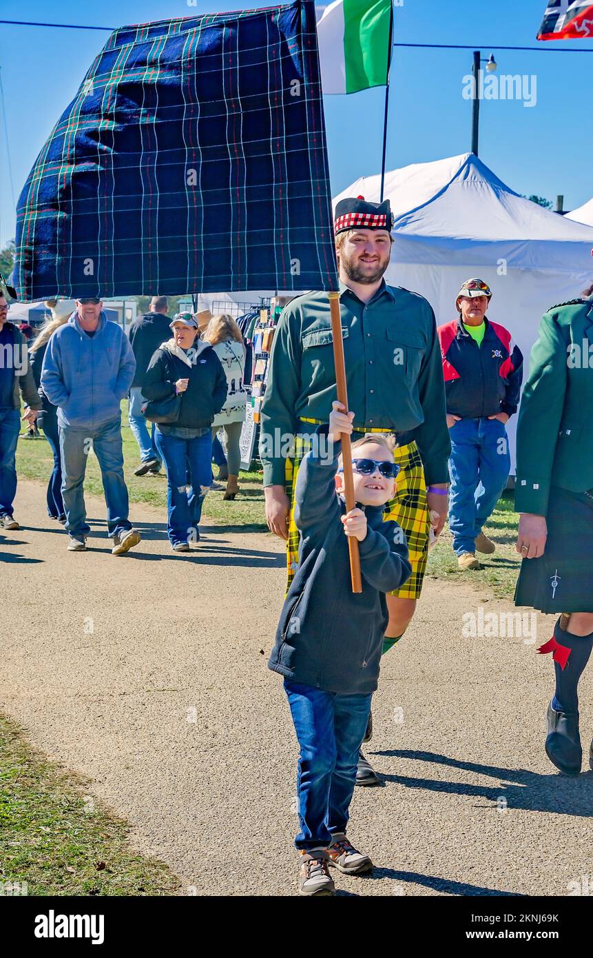 Durante la sfilata di tartan al Scottish Highland Games, 13 novembre 2022, a Gulfport, Mississippi, le persone portano dei banner tartan. Foto Stock