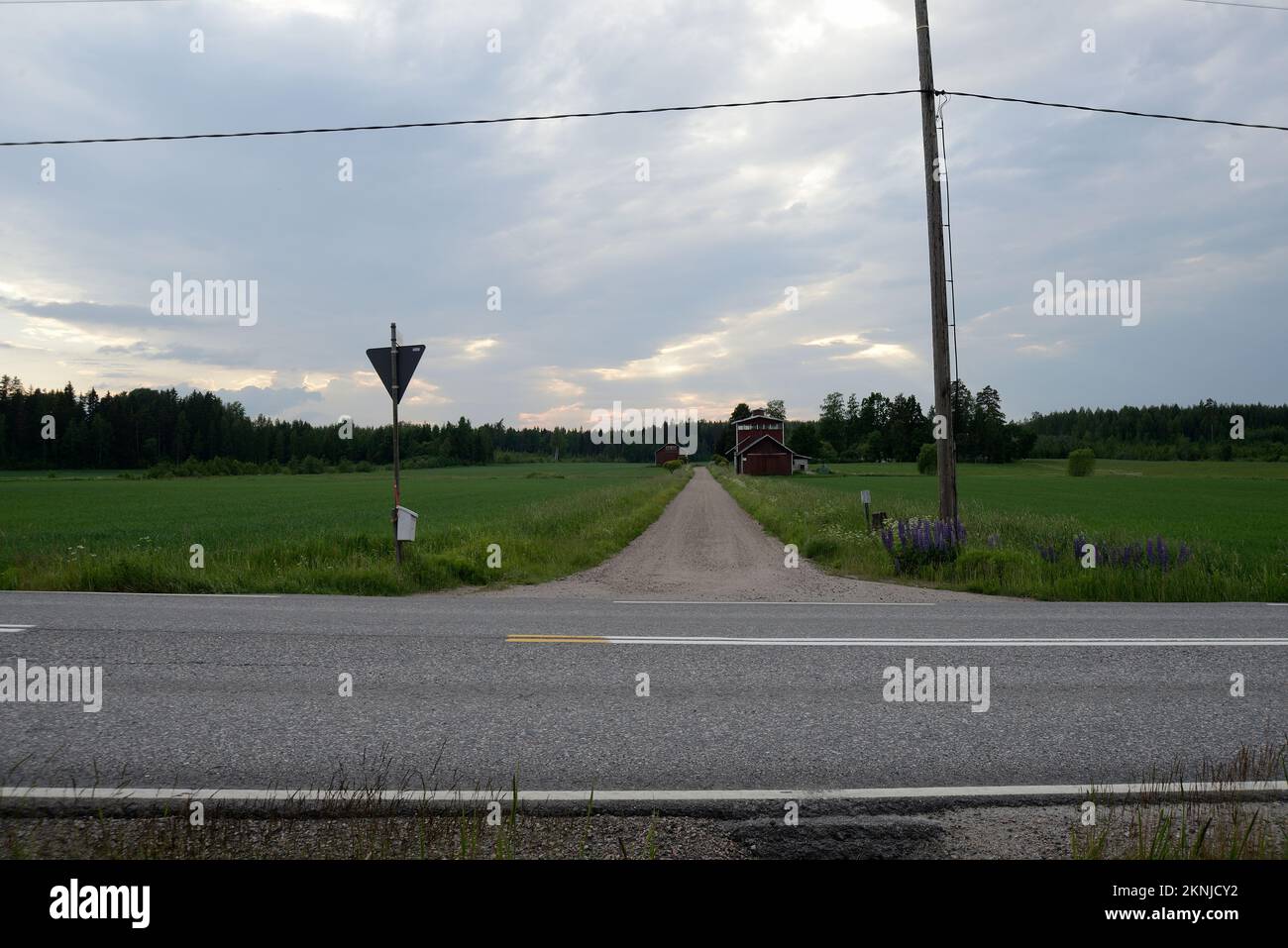 Crocevia di strade sterrate e asfaltate in Finlandia a metà estate Foto Stock