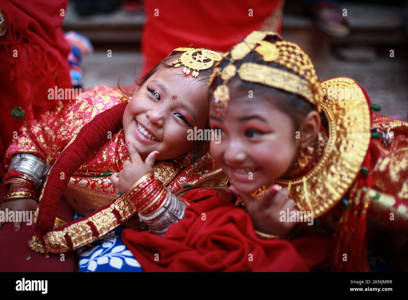 Bhaktapur, Nepal. 27th Nov 2022. Le ragazze si posano per la macchina fotografica mentre partecipano alla cerimonia di Ihi tenuta al Tempio di Chandeswari. Durante la cerimonia, le giovani ragazze di età compresa tra i 5 e i 9 anni della comunità di Newar si sposano con un frutto sempre fresco 'Bel', considerato come un'incarnazione di lord Vishnu. Allo stesso modo, Bahra (o Gufa) è un'altra cerimonia in cui le giovani ragazze sono simbolicamente sposate con Dio Sole. Si ritiene che questo rituale impedisca alle ragazze lo stigma della vedovanza come anche se i loro mariti passassero via più tardi nella vita, sarebbero ancora sposate con gli dei Vishnu e Sole. Credito: ZUMA Foto Stock