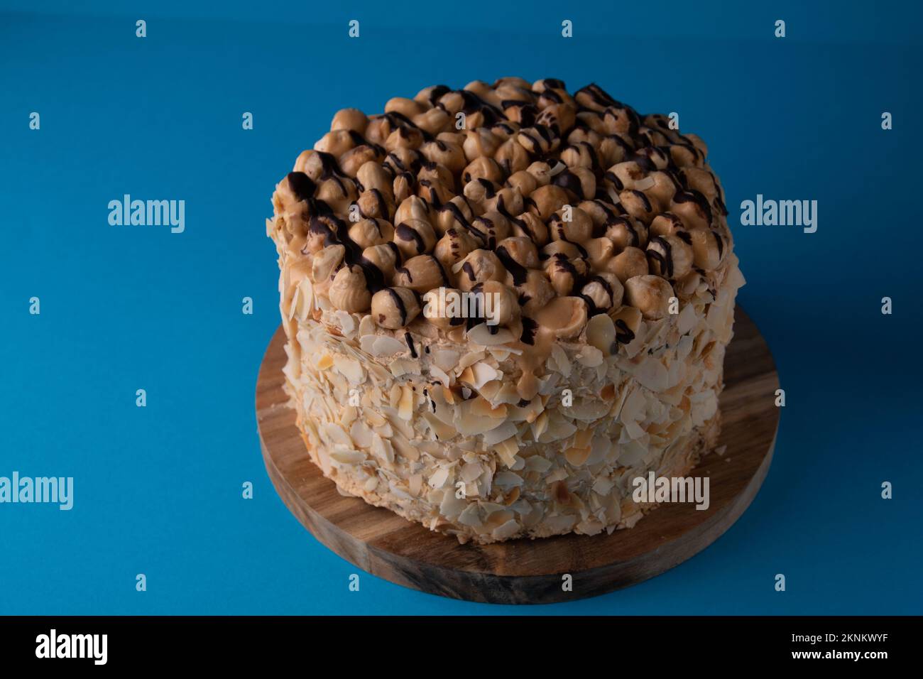 foto torta di noce su tavola rotonda su sfondo blu Foto Stock