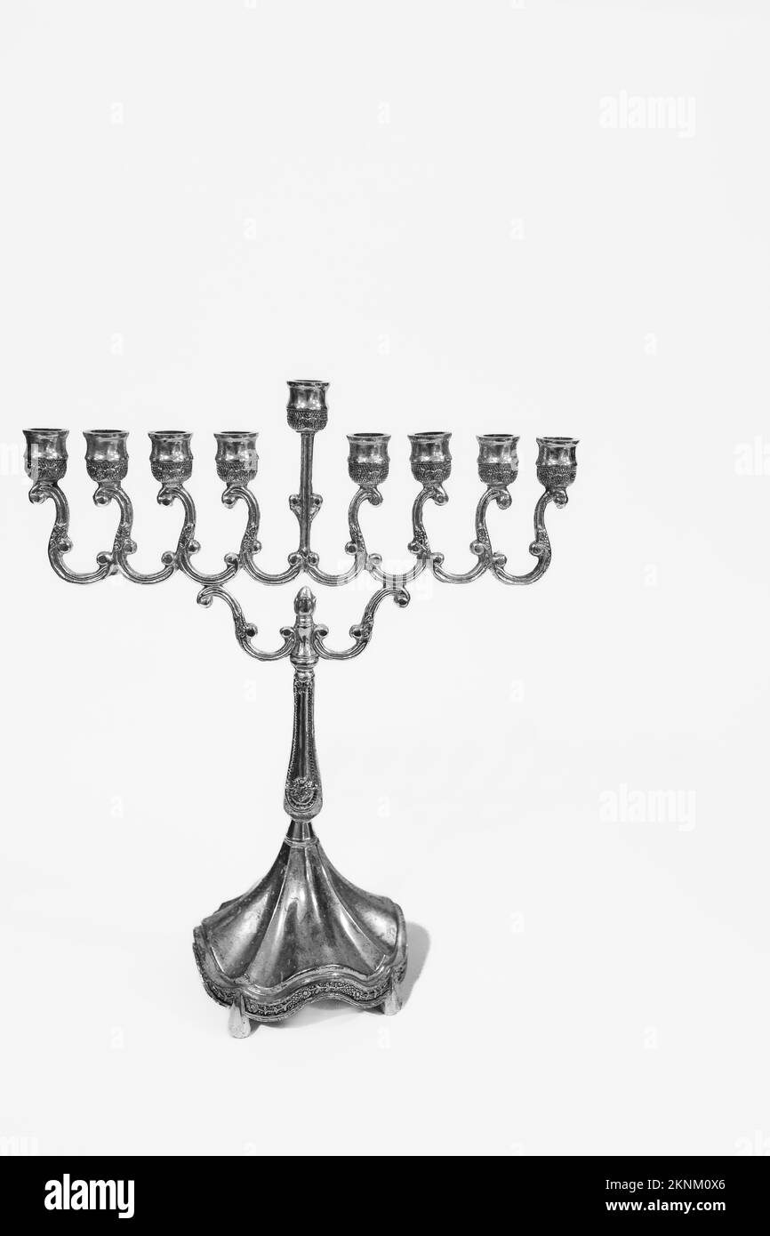 Bella argento hanukkah menorah. Antico menorah rituale di candela su sfondo bianco. Banner festivo ebraico con spazio copia, verticale Foto Stock