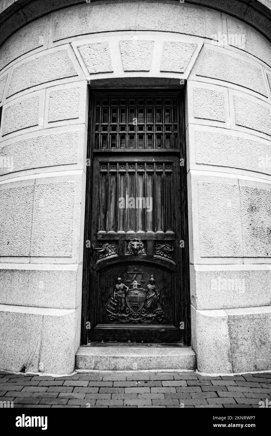 Una foto verticale di una vecchia porta con sculture in scala di grigi Foto Stock