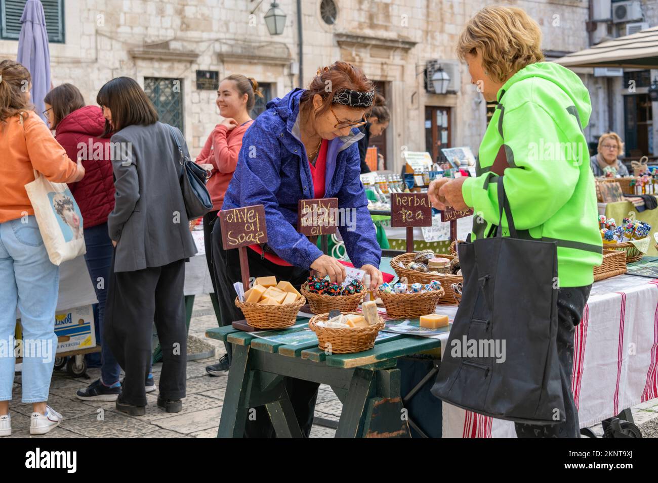 Dubrovnik Croazia, commerciante del mercato locale che vende olio di massaggio corpo e sapone di olio di oliva alla gente locale e ai turisti Foto Stock
