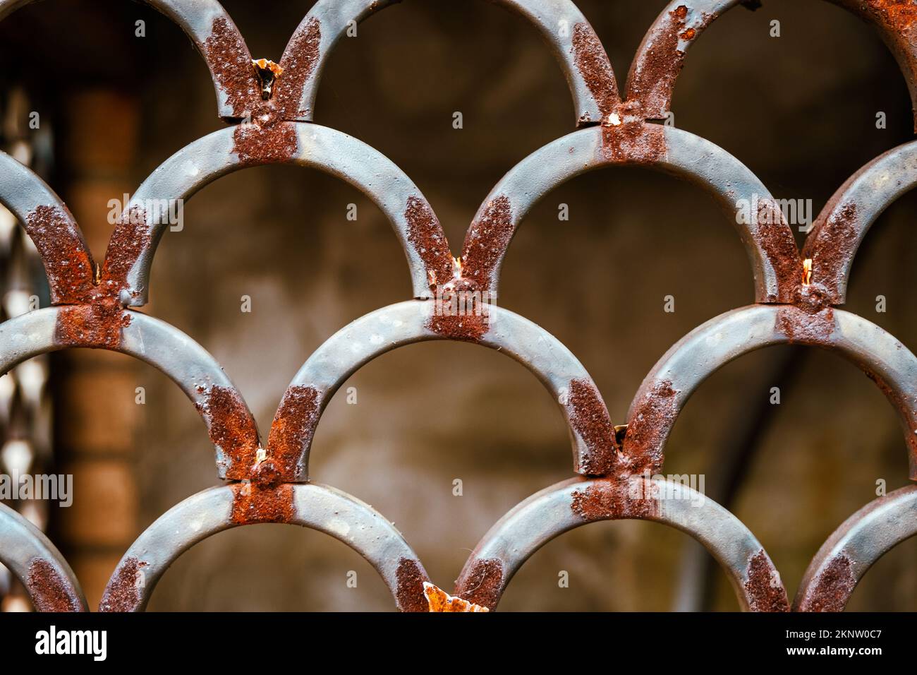 Vecchia grata di metallo usurata e arrugginita sotto le scale. Foto Stock