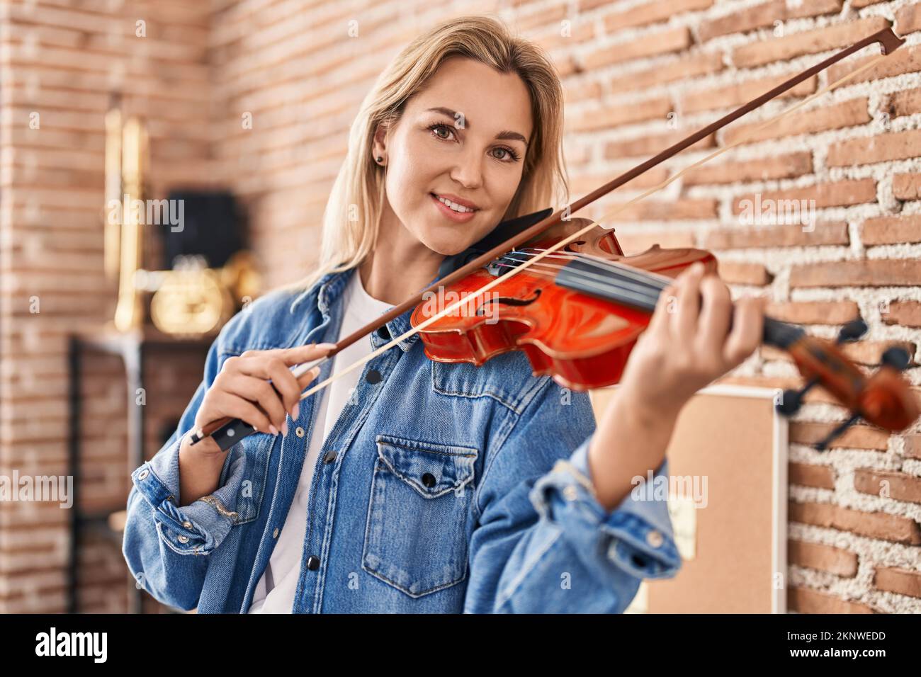 Giovane donna bionda musicista che suona violino in studio musicale Foto  stock - Alamy