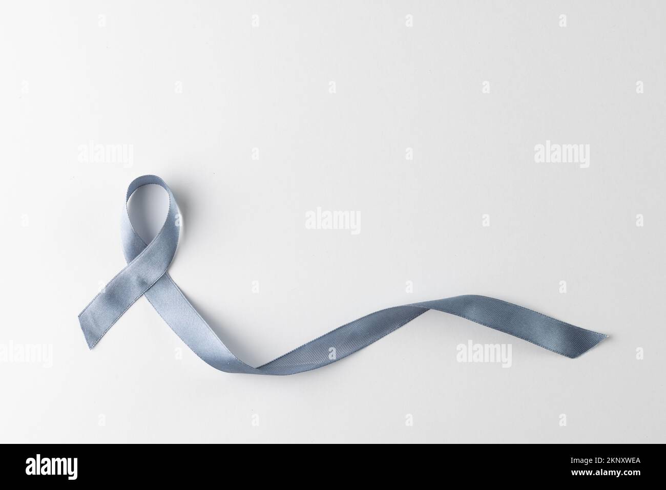 Composizione di nastro grigio per la consapevolezza del cancro, su sfondo bianco con spazio di copia Foto Stock